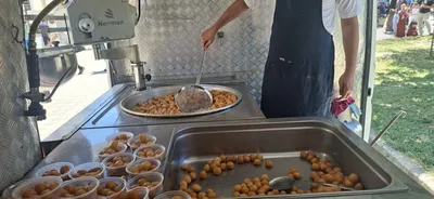 Usta kazandan kevgirle sıcak lokma çıkarıyor